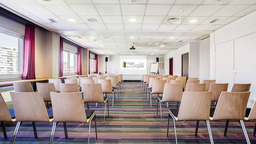 Main Conference Hall at Hôtel des Congrès with wooden chairs, ideal for corporate seminars.