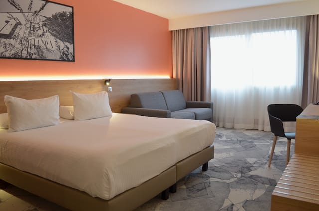 Modern hotel room with natural light, ideal for business travelers and meetings.