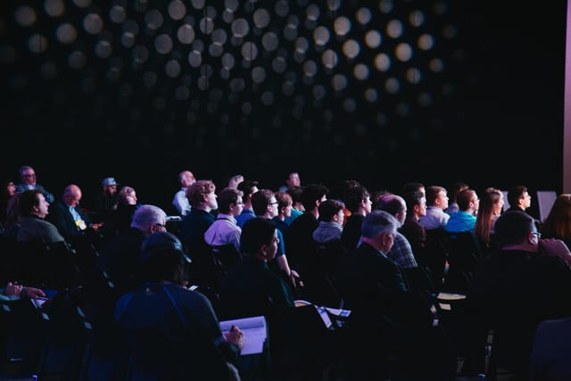 Engaged audience at Salle Bruxelles conference with dynamic lighting, networking event