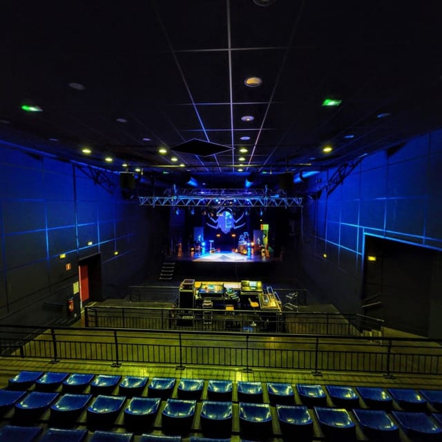 Concert hall with blue-lit stage, ideal for performances and gatherings. 