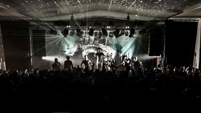 Energetic concert at Les Abattoirs SMAC with vibrant crowd and dramatic lighting.