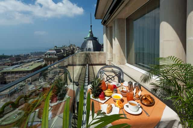 Elegant balcony breakfast meeting setup with fresh fruits and pastries at Hôtel de la Paix.