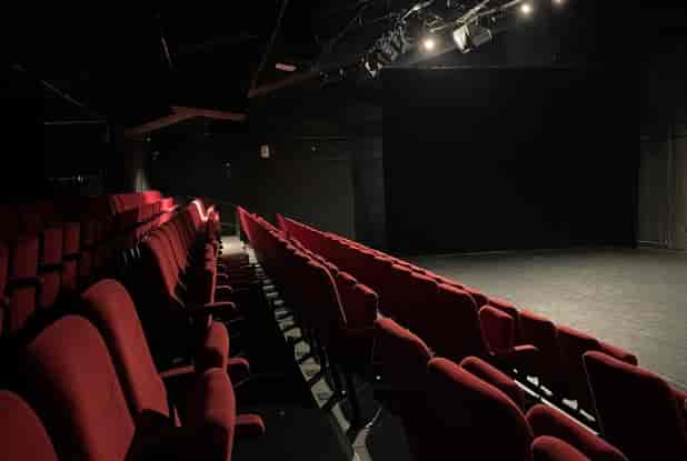 Intimate Théâtre de La Renaissance stage with red seating, perfect for performances and presentations.