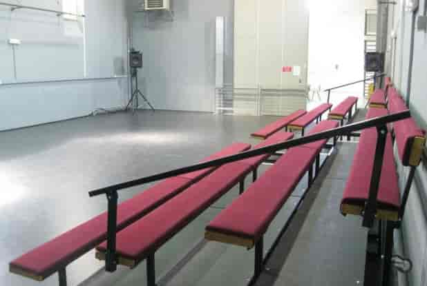 Spacious minimalist event venue Le Bac à Traille with red benches, perfect for workshops.