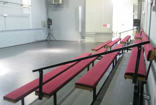 Spacious minimalist event venue Le Bac à Traille with red benches, perfect for workshops.
