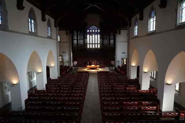 Elegant church sanctuary with stained glass windows for ceremonies and concerts.