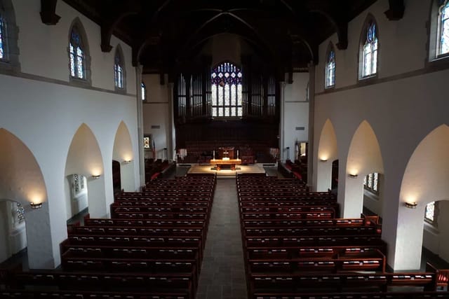 Elegant church sanctuary with stained glass windows for ceremonies and concerts.