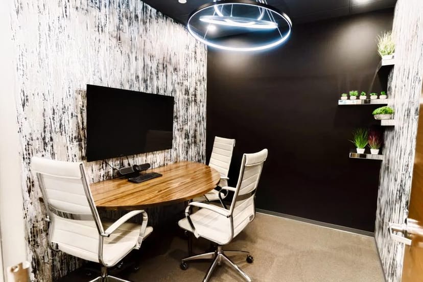 Sleek meeting room with round table for small team discussions in Lucid Private Offices.