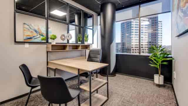 Modern small team office with natural light, ideal for meetings or brainstorming sessions.