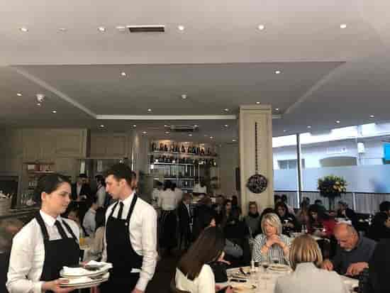 La Petite Maison dining room, bustling restaurant ideal for corporate networking events.