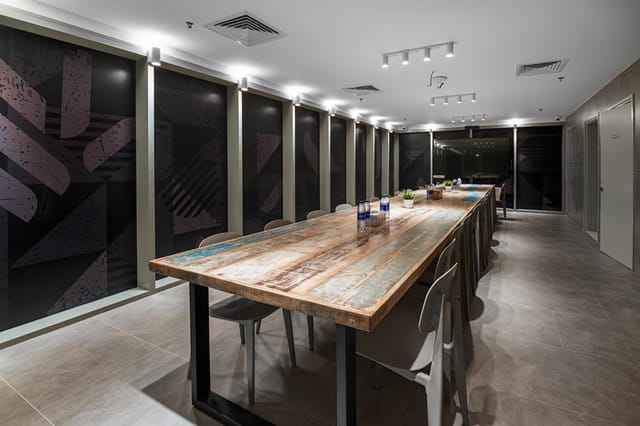 Outdoor Garden Mezzanine at Emirates Sports Complex, modern meeting space with wooden table.