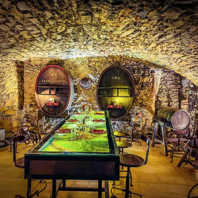 Intimate dining at Café des Fédérations with rustic stone walls, perfect for wine tastings.