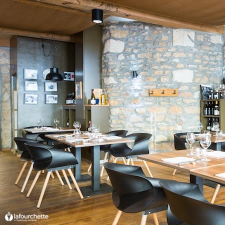 Modern dining space with rustic stone wall for private events and gatherings.