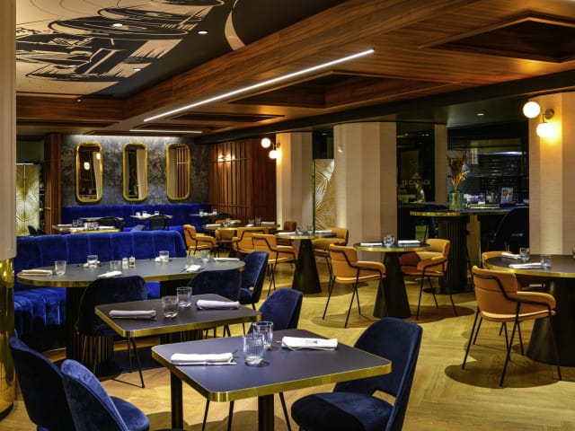 Elegant restaurant interior with blue and gold accents, perfect for corporate events.