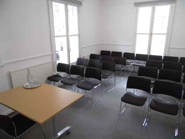 F17 Meeting Room with black chairs, bright windows for engaging meetings and events.