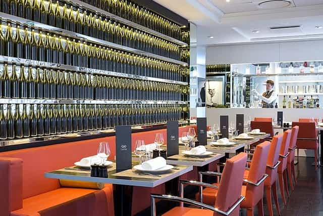 Côté Bellecour Lounge Bar at Le Royal Lyon, elegant wine wall, perfect for corporate events.
