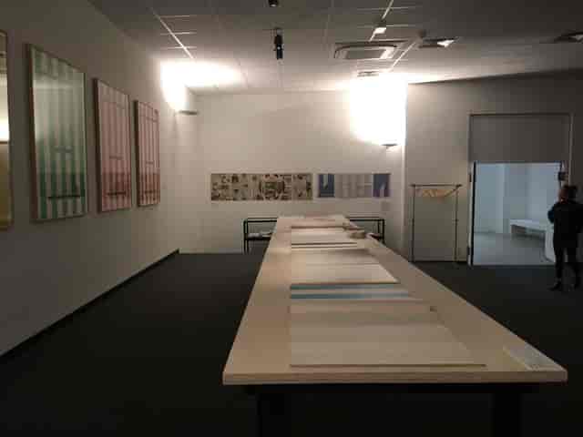 Art exhibition in Institut d'art contemporain auditorium, featuring a long display table.