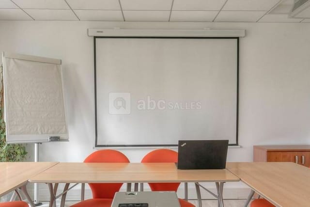 Clean training room with large screen, ideal for presentations and workshops.