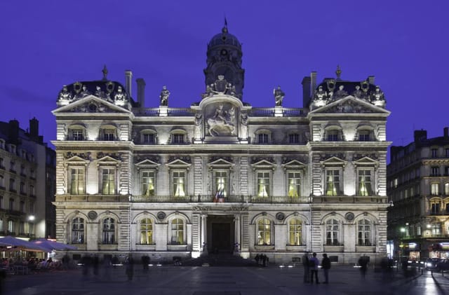 Historic Hôtel de Ville in Lyon illuminated at dusk, perfect for gala dinners and conferences.