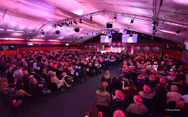 Vibrant event at Matmut Stadium with attendees in pink hats, perfect for networking.