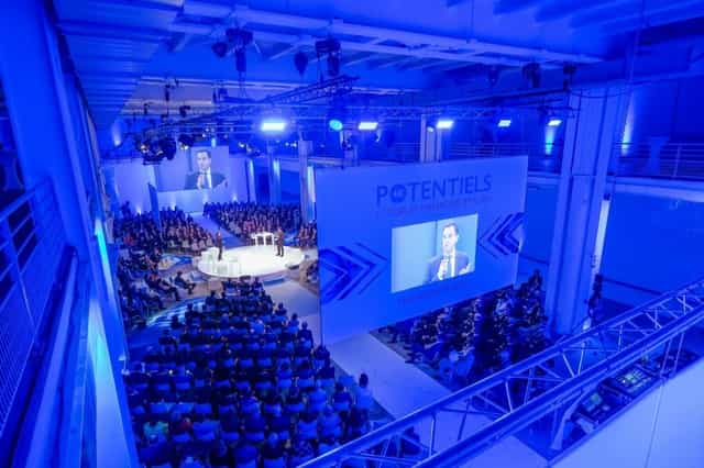 Dynamic conference auditorium at Espace 1930 with tiered seating and blue lighting.