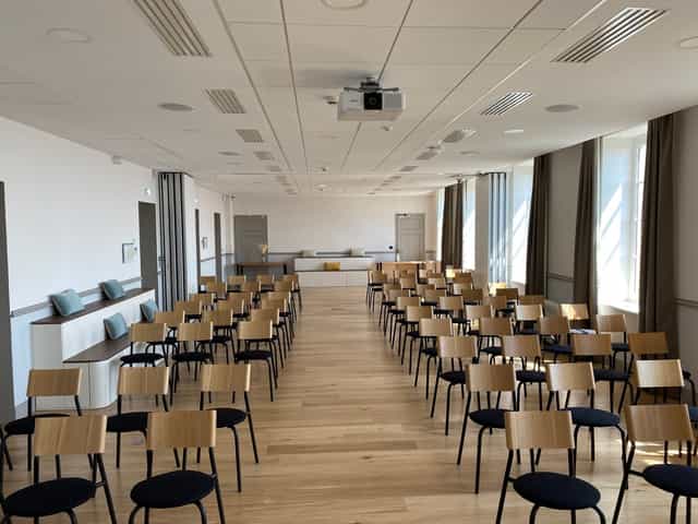 Conference room in Carré Fourvière with wooden chairs, ideal for seminars and workshops.
