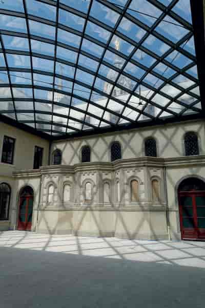 Elegant indoor venue La Cour Carrée with glass roof for corporate events and gatherings.