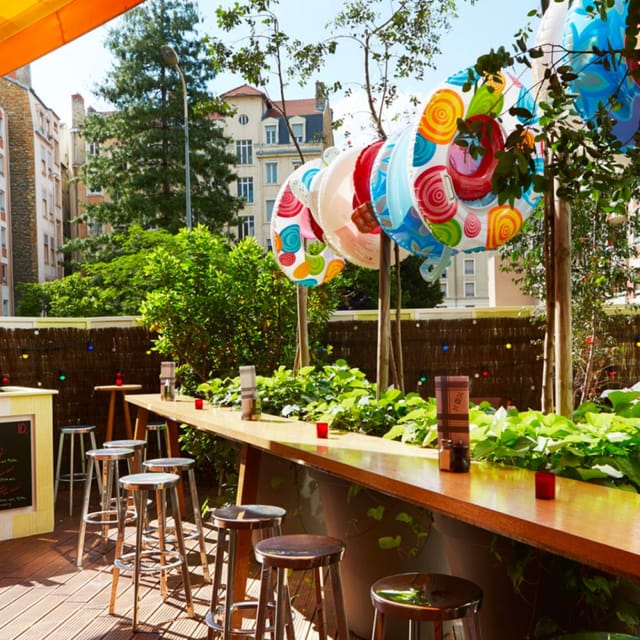 Vibrant outdoor event space at Mama Shelter Lyon with colorful decor and bar seating.
