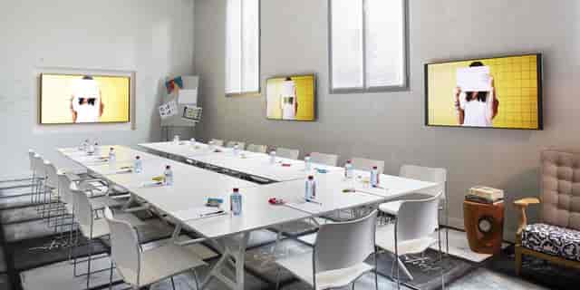 Modern meeting room at Atelier 4, designed for workshops with a sleek table and AV technology.