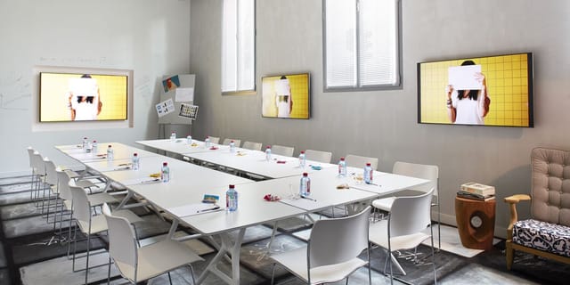 Modern meeting room at Atelier 4, designed for workshops with a sleek table and AV technology.