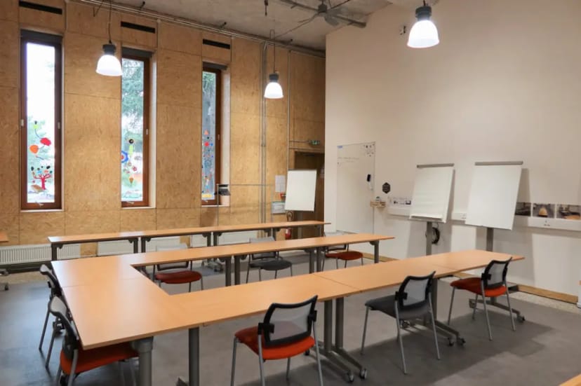 Versatile workshop room with modular tables and natural light for creative team sessions.