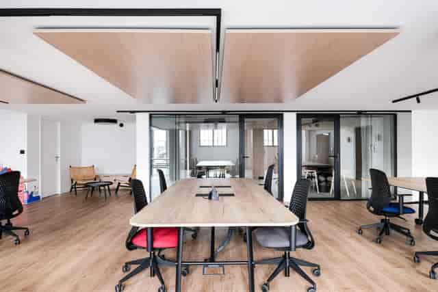 Modern meeting room with central table and ergonomic chairs, ideal for collaborative events.