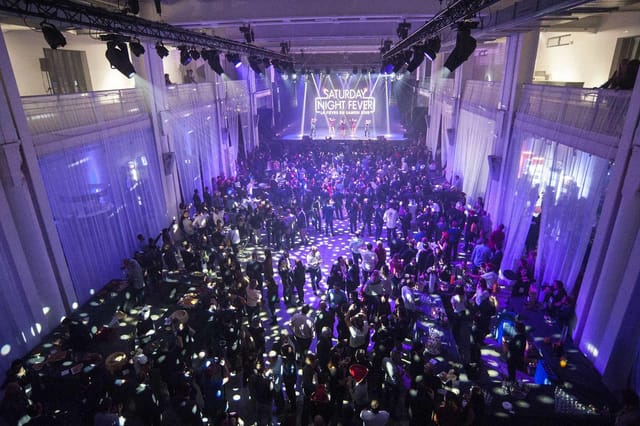 La Sucrière event space in Lyon with dramatic lighting and lively atmosphere.