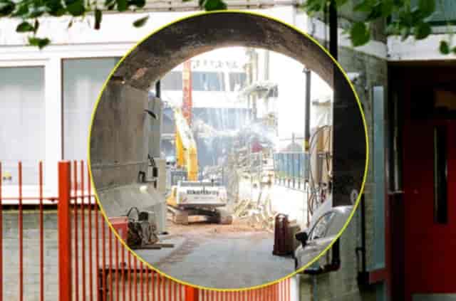 Out-building construction site with urban archway, highlighting event logistics challenges.