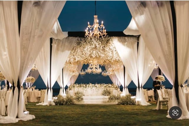 Elegant outdoor wedding reception setup in Dubai with white draping and floral decor.
