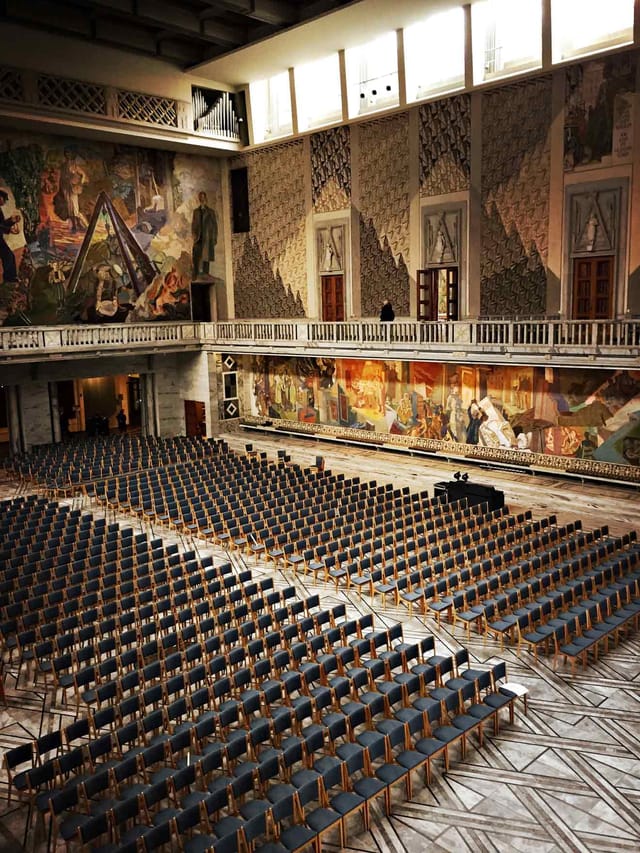 Toghallen event hall at Nobel Peace Center with grand mural and organized seating for conferences.