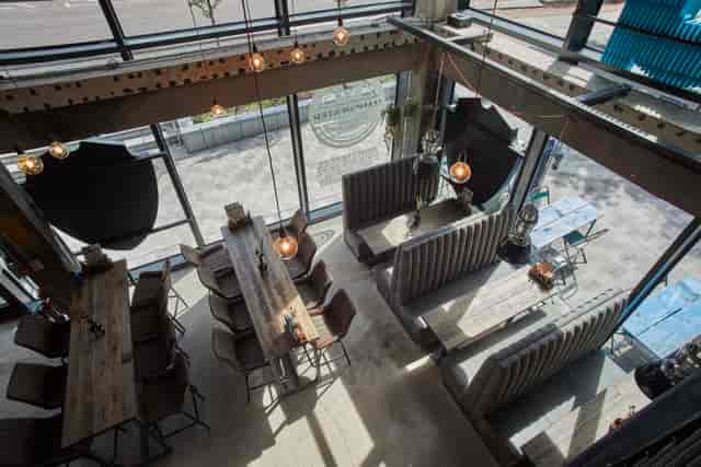 Modern beer garden at BrewDog Manchester, featuring communal tables for meetings.
