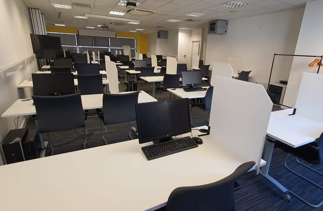 Modern IT test centre workspace with computers, ideal for corporate workshops and training.
