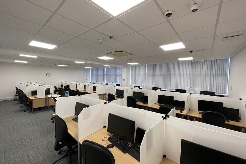 Test Centre Sourcing setup with computer workstations for hybrid meetings and training events.