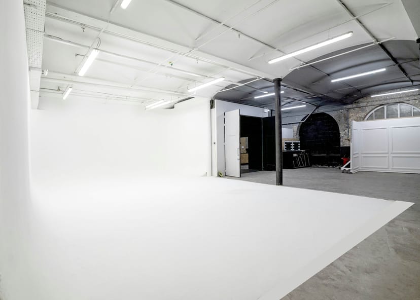 Minimalist event space with white backdrop, ideal for corporate meetings and creative events.