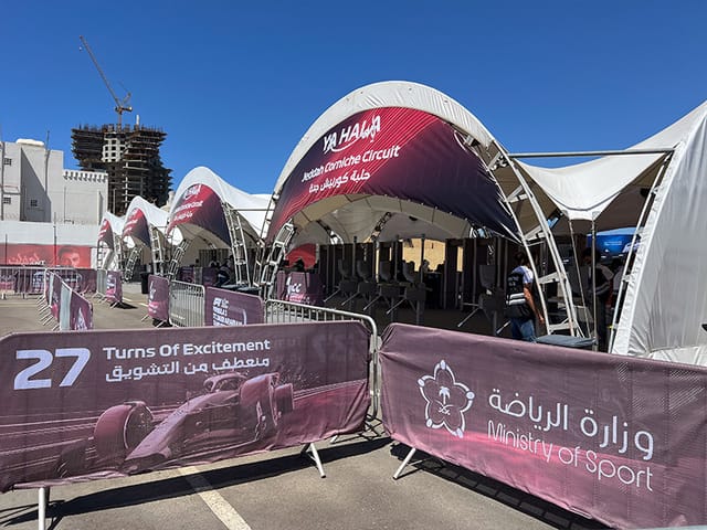 High-profile motorsport event venue with branded tents and engaging signage.