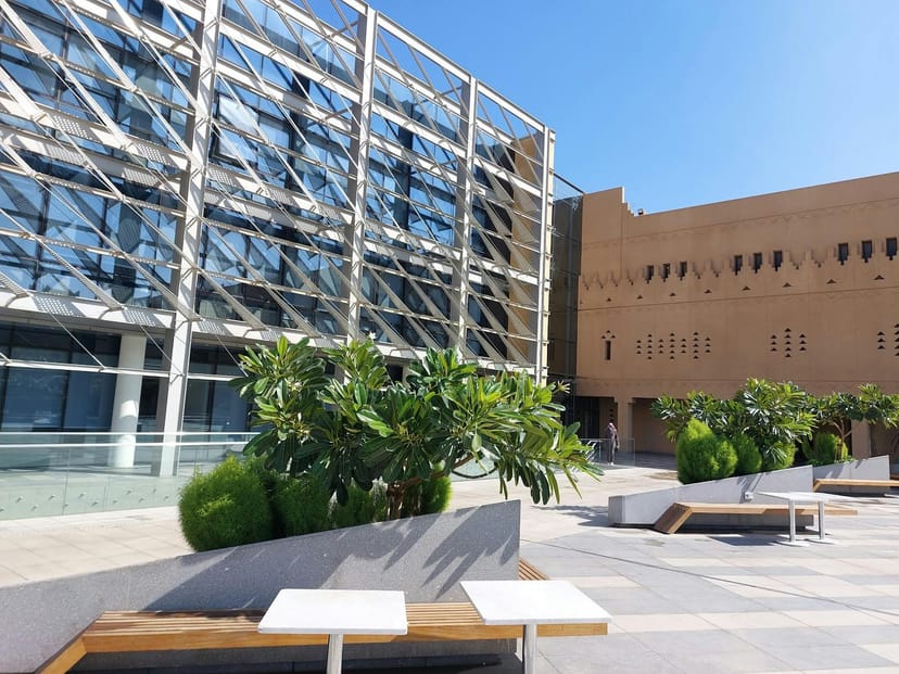 "Modern Media Center in Riyadh for outdoor events with sleek glass facade and greenery."
