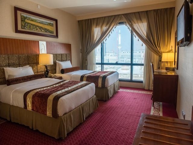 Al Safwah Hotel suite with twin beds, ideal for conference attendees and events.