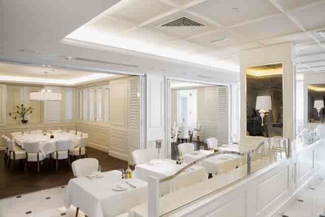 Elegant Bistro in La Serre, ideal for events and dining with round tables and soft lighting.