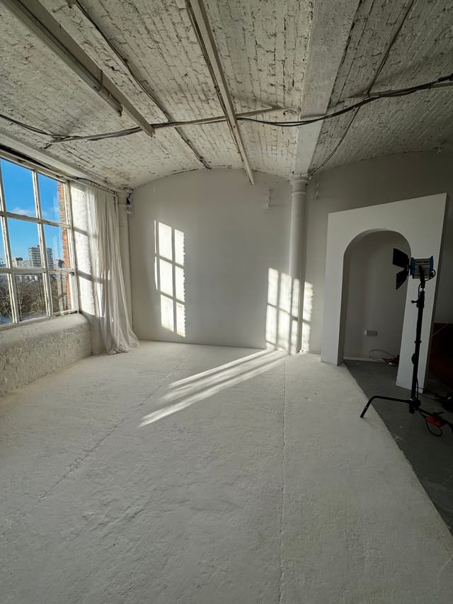 Bright studio with large windows for creative workshops and intimate meetings.