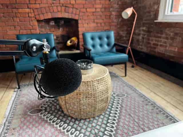 Stylish recording studio with warm brick backdrop, ideal for podcasts and meetings.