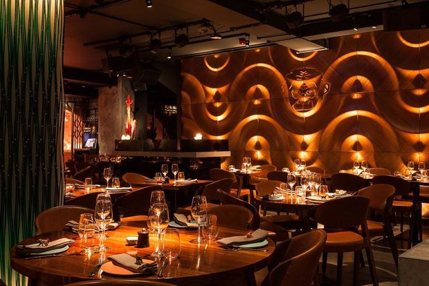 Stylish bar in Mnky Hse with wave-patterned walls, perfect for intimate dinners and events. - Banner