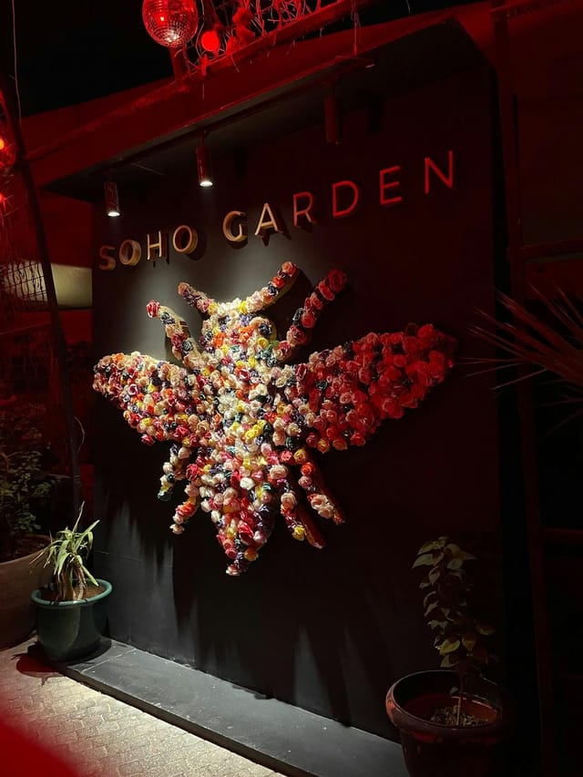 Vibrant bee floral installation in Soho Garden, perfect for events and photography.