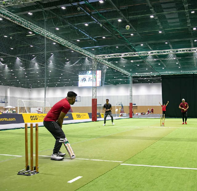 Indoor cricket field in Dubai Sports World for corporate events and team-building activities.