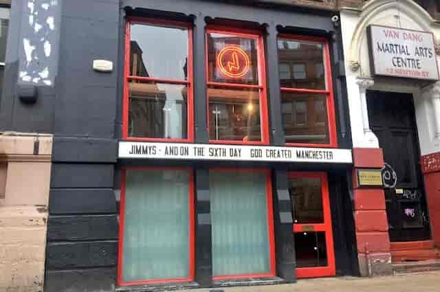 Vibrant bar façade with red accents, ideal for events and workshops in Manchester.